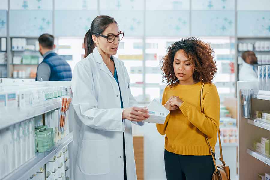 A woman pharmacist helps a patient | 900x600