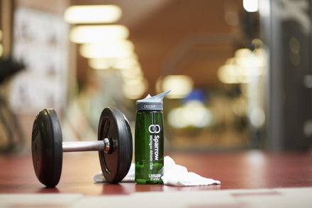 Weight, water bottle and towel on floor of gym