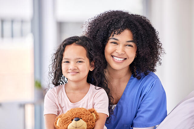 Nurse and child with teddy bea