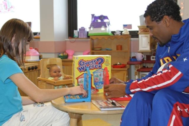Harlem Globetrotter team member entertains children with basketball